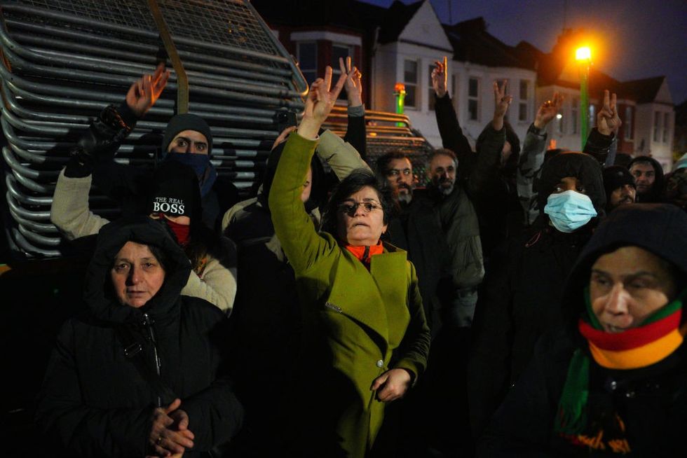 \u200bKurdish people shout as they block barriers from being unloaded and used to stop access to a road leading to a Kurdish community centre