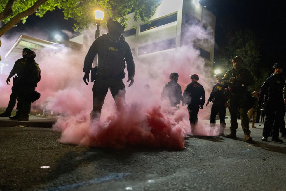 \u200bLaw enforcement officers deploy smoke grenades to disperse protesters gathered at the Ice Headquarters in Portland