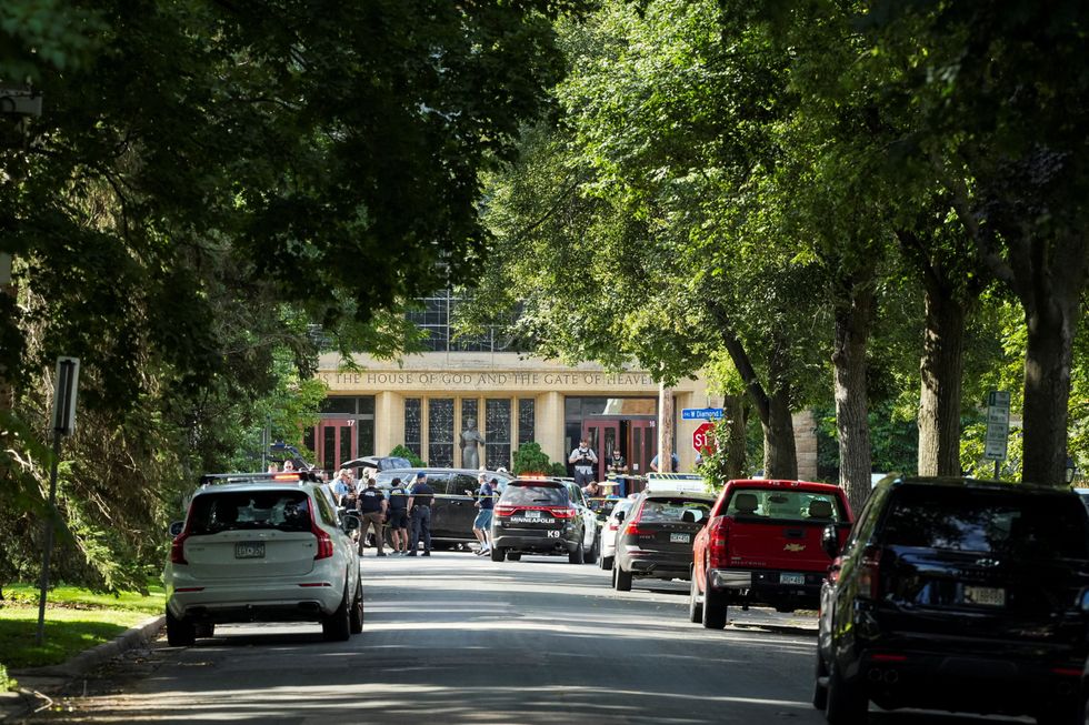 \u200bLaw enforcement officers gather outside Annunciation Church following a mass shooting