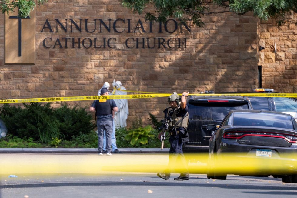 u200bLaw enforcement officers set up barriers after a shooting at Annunciation Church