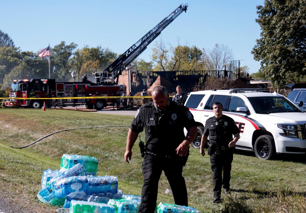 \u200bLaw enforcement officers work near the burnt Church of Jesus Christ of Latter-day Saints,