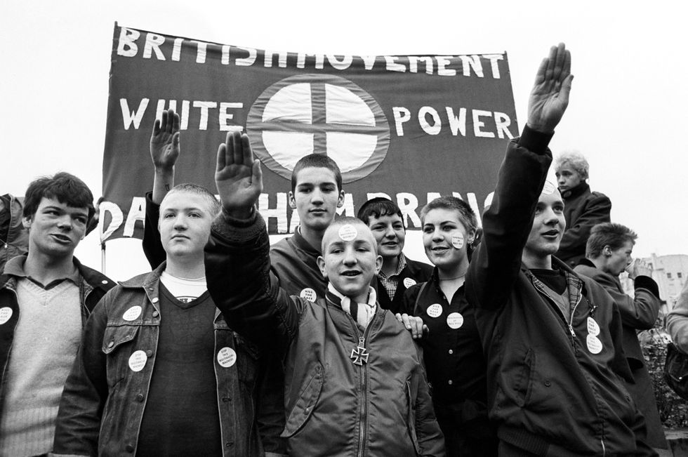 \u200bMembers of the British Movement hold up a banner with 'White Power' and give Nazi salutes