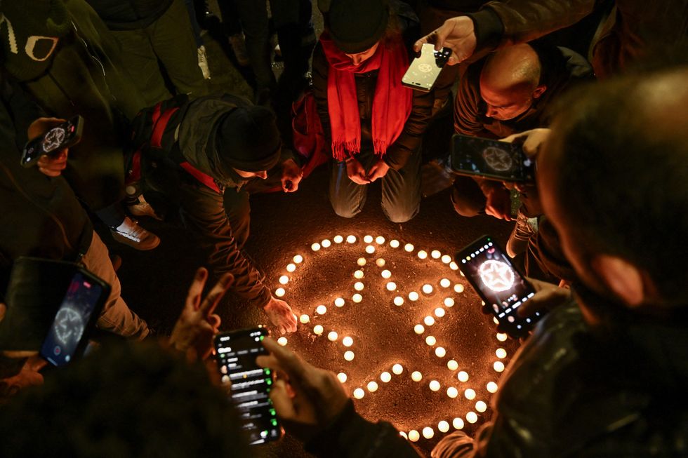 \u200bMembers of the Kurdish community and locals light candles arranged to depict the star in the Kurdistan Workers' Party (PKK) flag