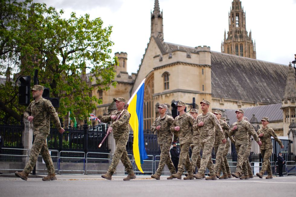 \u200bMembers of the Ukrainian military march past the Palace of Westminster in central London,