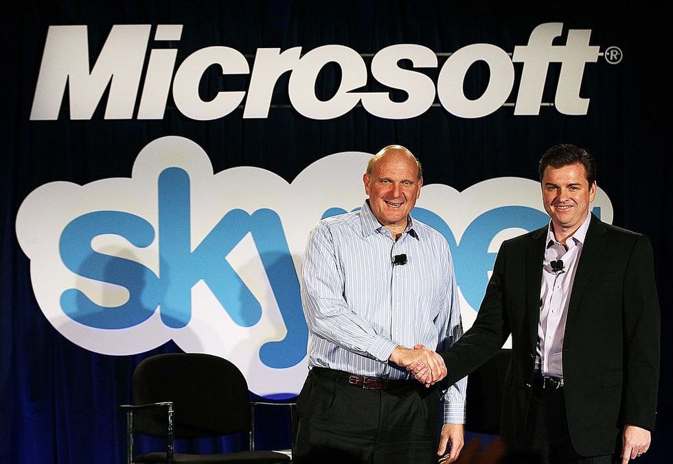 \u200bMicrosoft CEO Steve Ballmer (L) shakes hands with Skype CEO Tony Bates following the acquisition in 2011