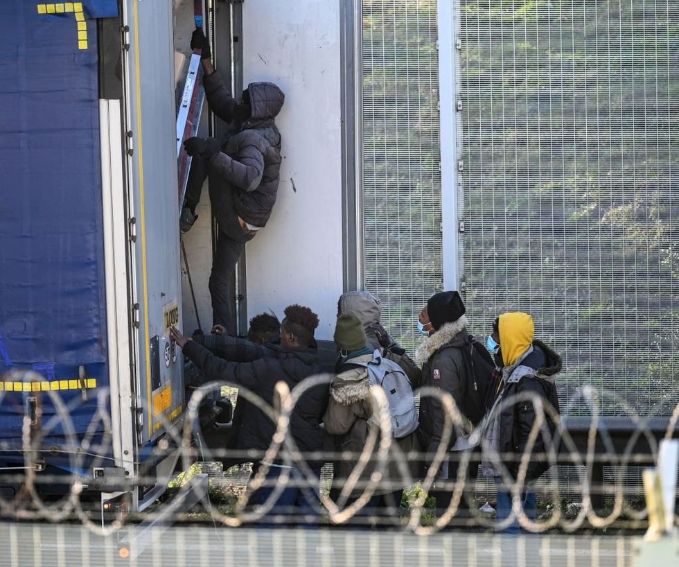 \u200bMigrants climb into the back of lorries bound for Britain