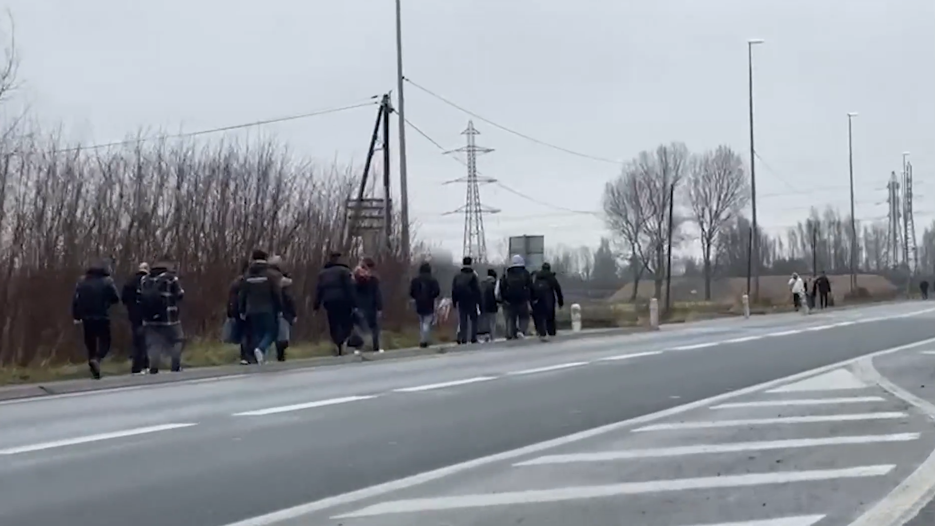\u200bMigrants walking down road in Calais
