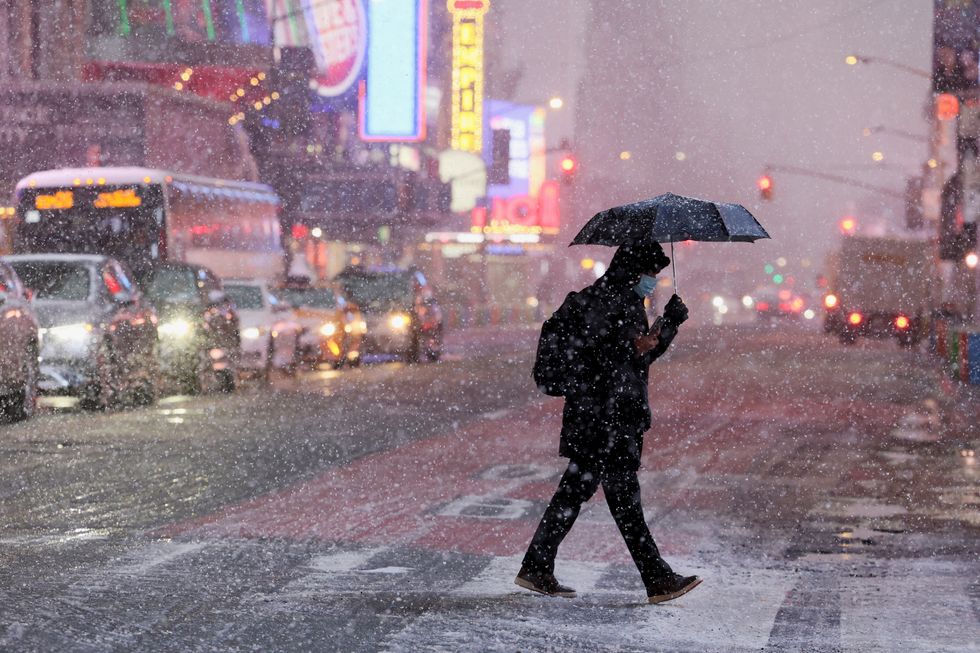 \u200bMorning commuters make their way through wind and snow during a Nor'easter winter storm