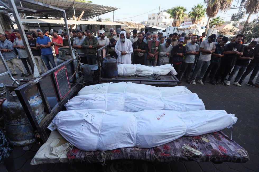 \u200bMourners pray near the bodies of Palestinians, who were killed in an Israeli strike