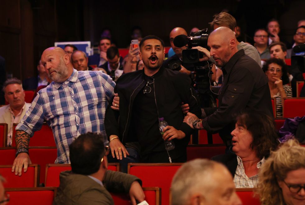 \u200bOne of the protesters is dragged out of the venue