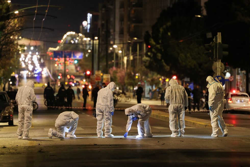 \u200borensics officers investigate the area of a bomb blast outside the Hellenic Train offices, in Athens
