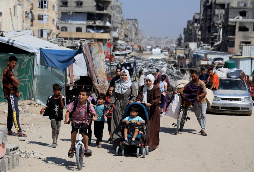 \u200bPalestinians carry their belongings as they flee their homes after the Israeli army issued evacuation orders, in Khan Younis