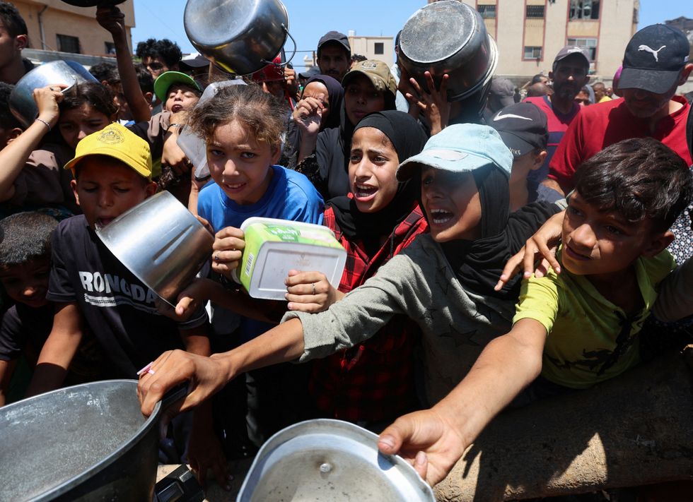 \u200bPalestinians gather to receive food from a charity kitchen, amid a hunger crisis, in Nuseirat, central Gaza