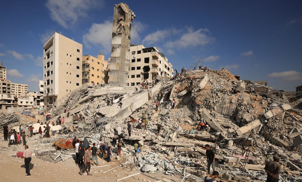\u200bPalestinians inspect the site of an Israeli air strike from earlier today that destroyed a residential building, in Gaza City,