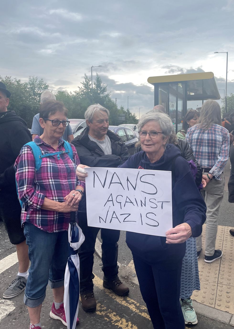 \u200bPat holds up a sign in Liverpool that says "nans against Nazis"