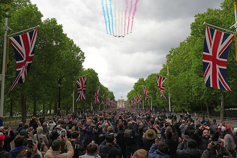 \u200bPeople gather on The Mall as the Red Arrows perform a fly past over Buckingham Palace