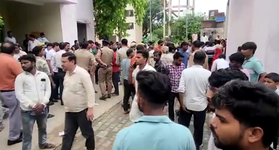 \u200bPeople gather outside the local hospital.