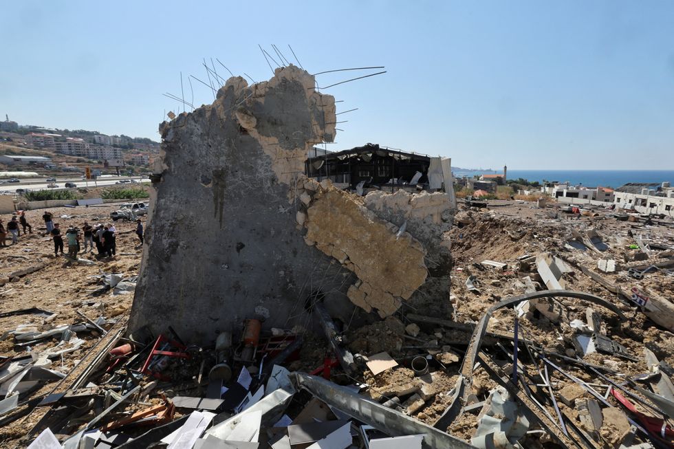 \u200bPeople inspect the damage at the site of an Israeli strike that hit the Lebanese seaside town of Jiyeh