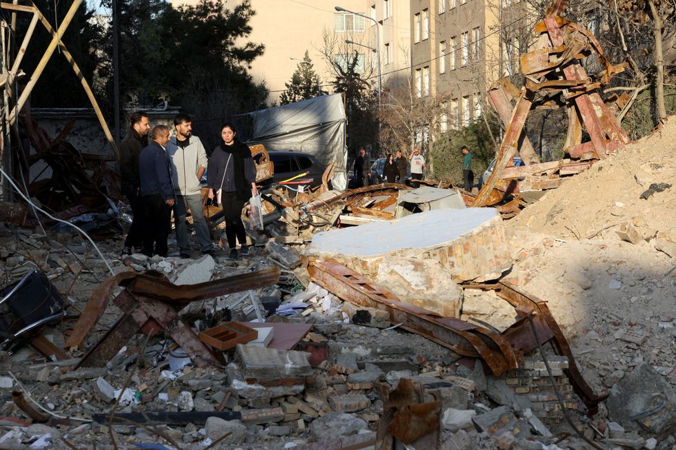 \u200bPeople look at a destroyed building following a strike, amid the U.S.-Israeli conflict with Iran, in Tehran