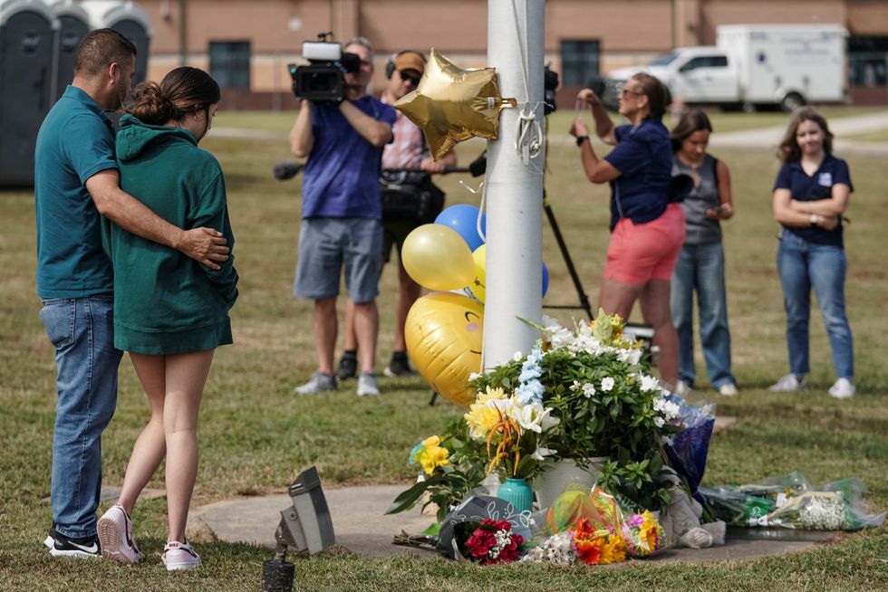 \u200bPeople pay their respect at a makeshift memorial at Apalachee High School