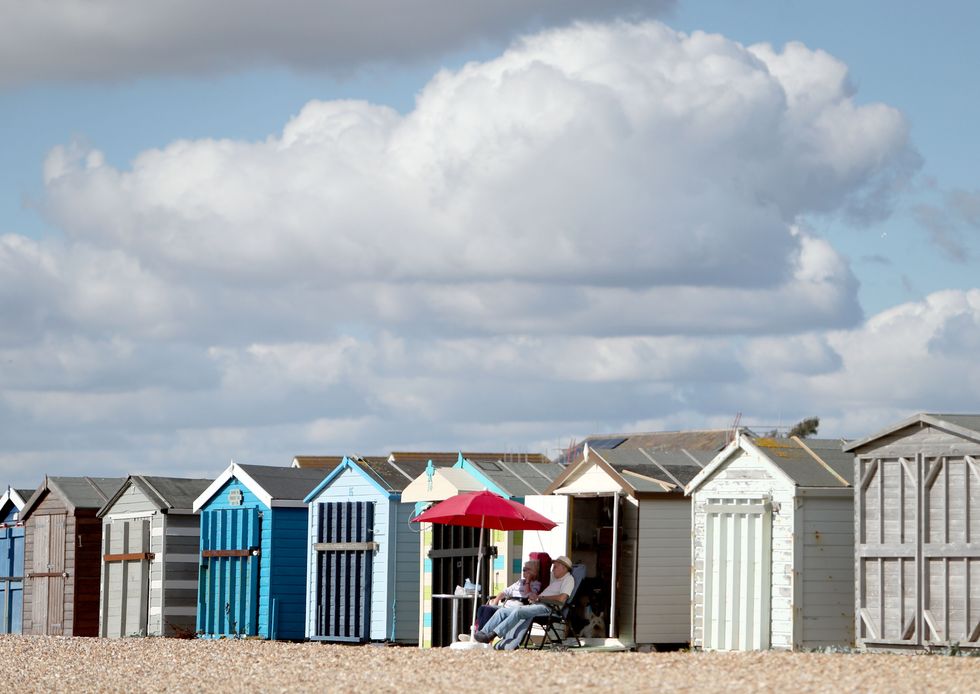 \u200bPeople relax in the autumn sun on the beach in Hayling Island, Hampshire.