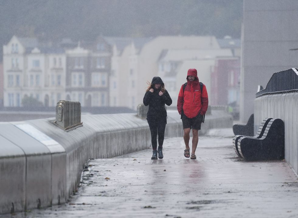 \u200bPeople walking along the Dawlish sea wall in Teignbridge, Devon