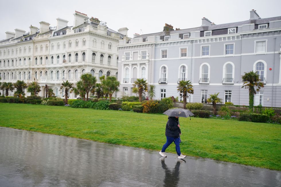 \u200bPeople walking in the heavy rain at Plymouth Ho