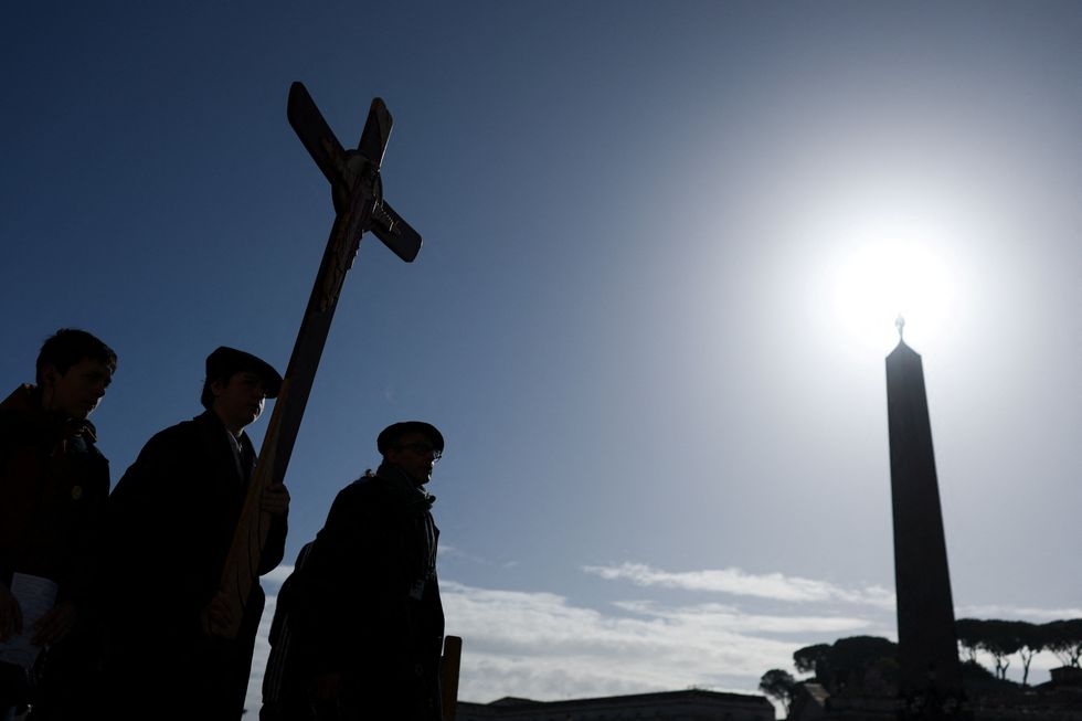 \u200bPilgrims carry a cross as Pope Francis continues his hospitalization