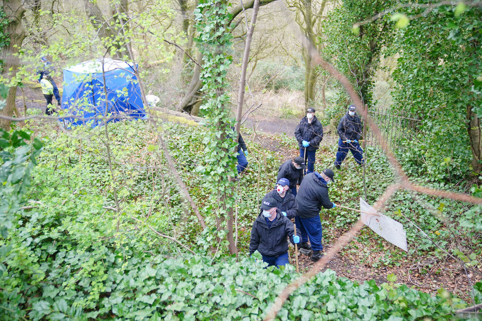 \u200bPolice officers carry out searches beside a forensic tent at Kersal Dale, Salford