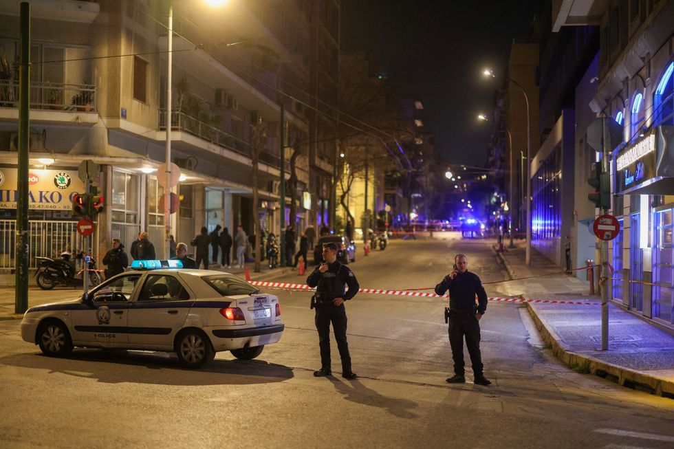 \u200bPolice officers secure the area of a bomb blast outside the Hellenic Train office