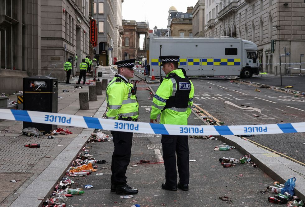 \u200bPolice officers work at the scene after an incident where a car plowed into a crowd of Liverpool fans