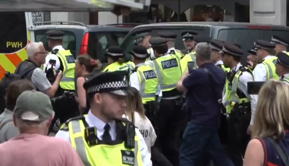 \u200bPolice usher away a protester