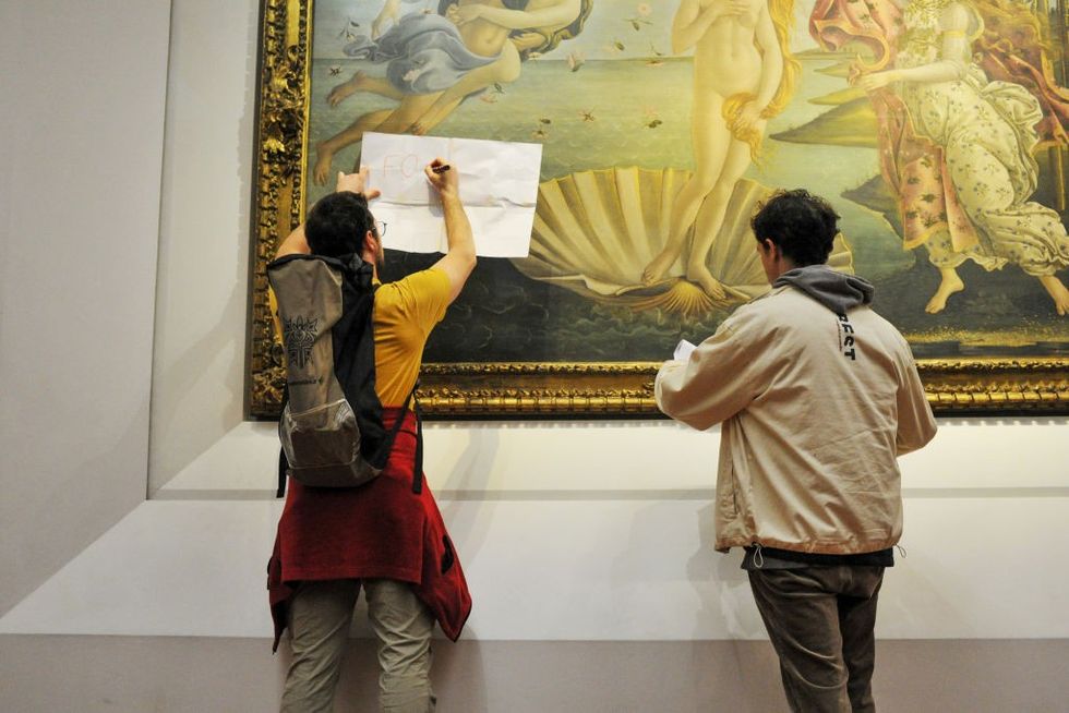 \u200bPosters were pinned to the protective glass covering the painting