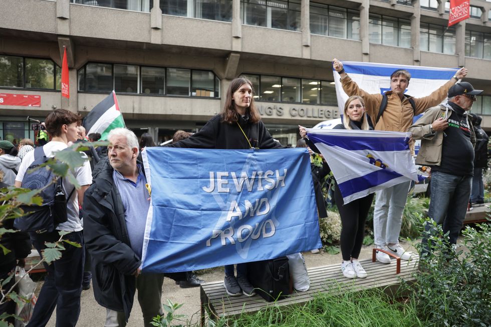 \u200bPro-Israel counter-demonstrators display signs and flags near King's College in Gaza