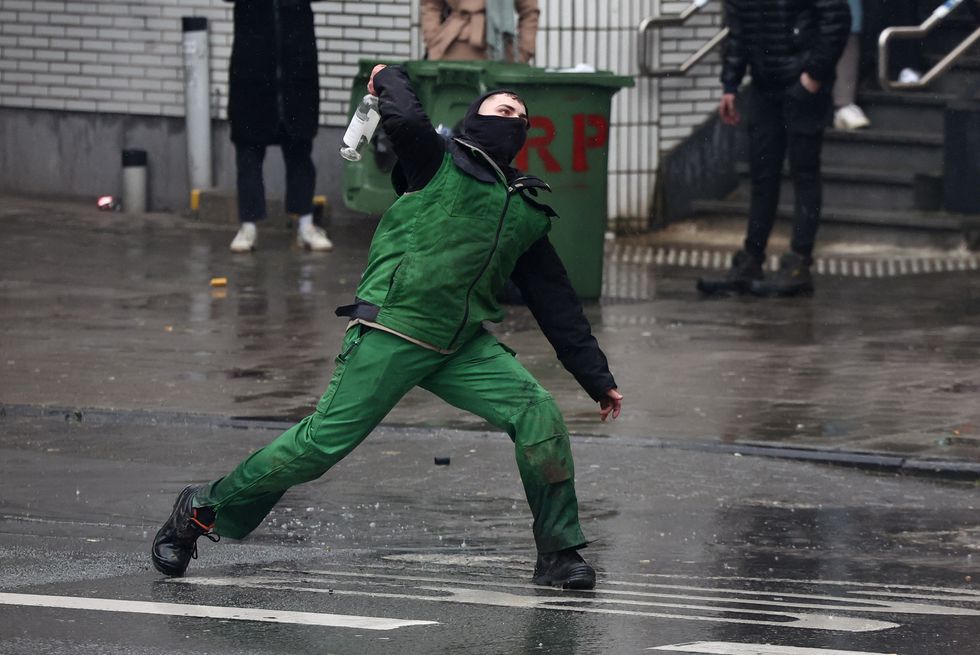\u200bProtester launches empty bottle at police during farmers protest in Brussels