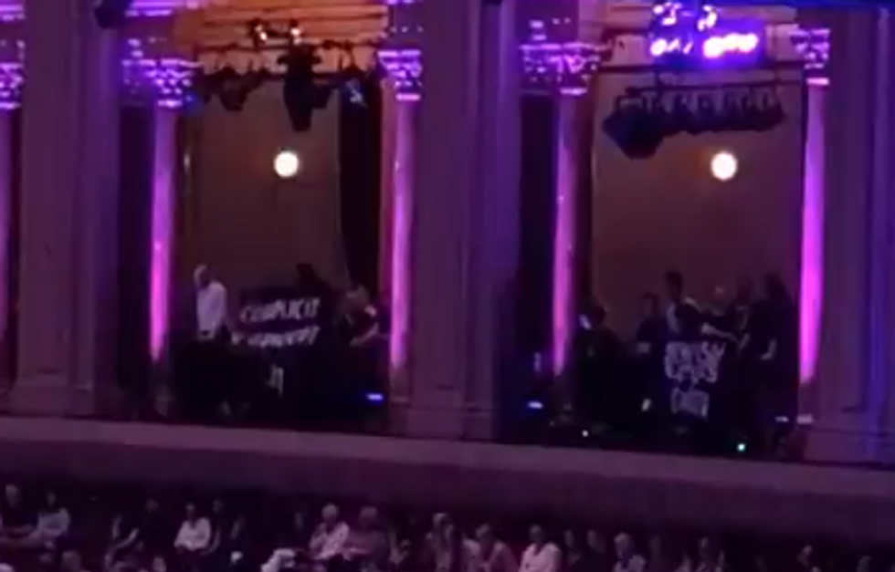 \ U200bProtesters držel nápisy, které říkaly „spoluúčast na genocidu“