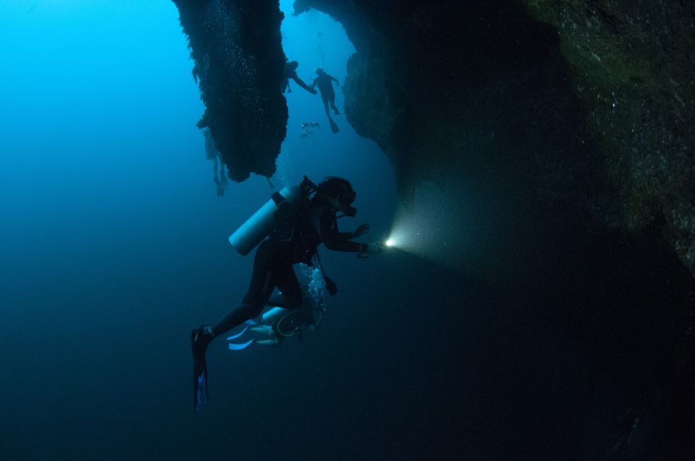 \u200bScuba divers explore the stalactites inside the Great Blue Hole,