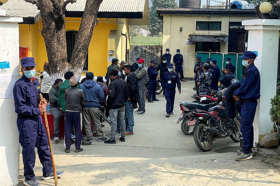 \u200bSecurity personnel stand guard as relatives of victims, who wer