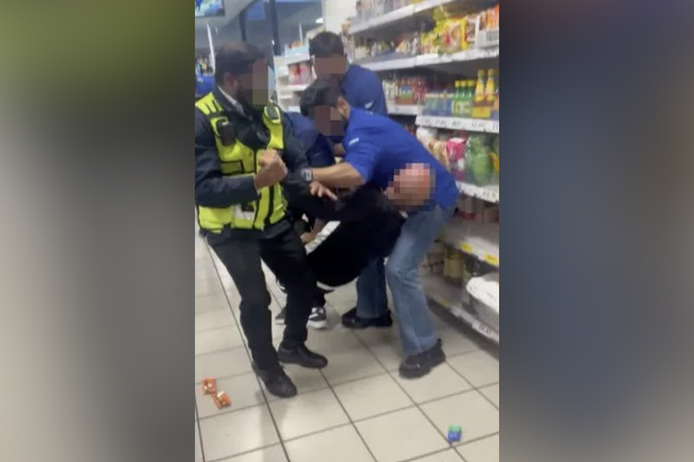 \u200bShop workers hold up the alleged shoplifter