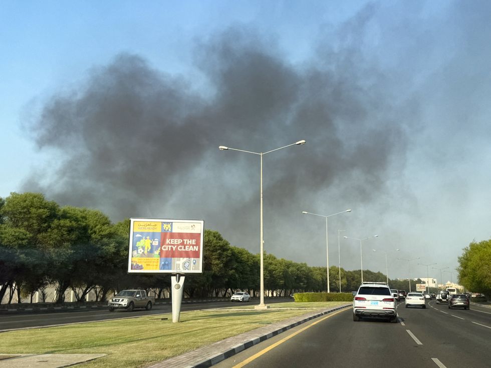 \u200bSmoke is seen rising past cars driving in Doha
