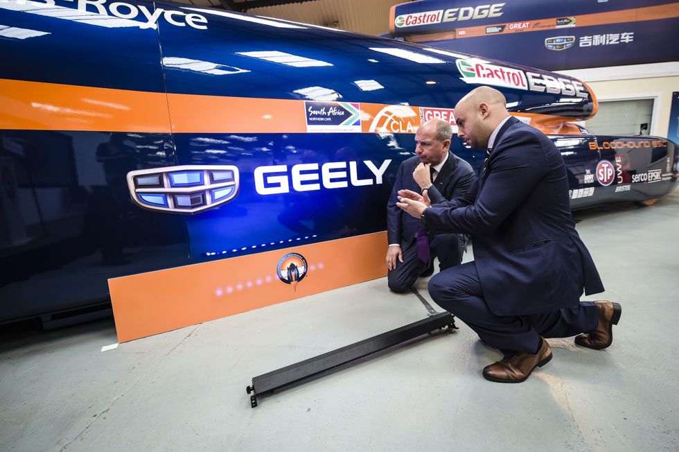\u200bStaff from Chinese automotive firm Geely inspect the new branding on the Bloodhound SSC (supersonic car)
