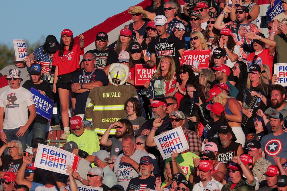 \u200bSupporters hold signs and a firefighter uniform reading "Compertore" during a campaign rally held by Republican presidential nominee