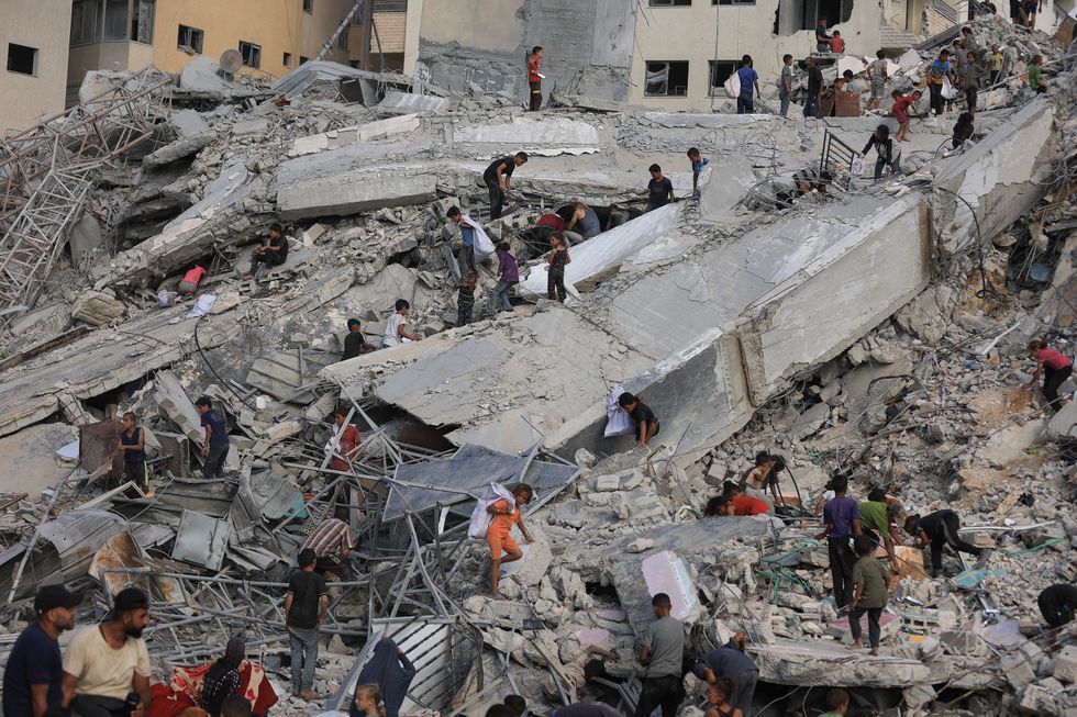 \u200bSurvivors pick through the rubble in Gaza City