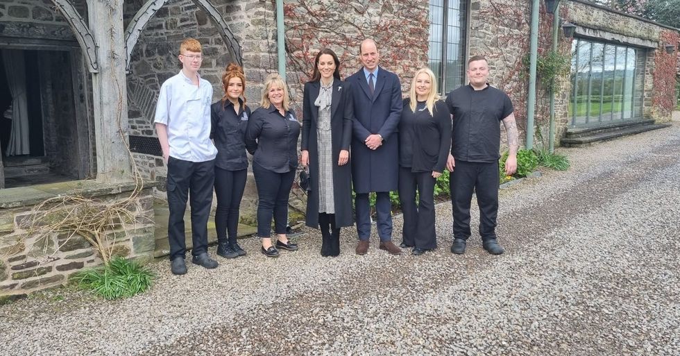 \u200bThe couple pose for a photo with staff at the bed and breakfast