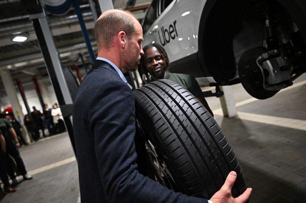 \u200bThe Prince of Wales holding a car tyre during a visit to the 2023 Earthshot Prize Finalist, ENSO, in Brentford, west London