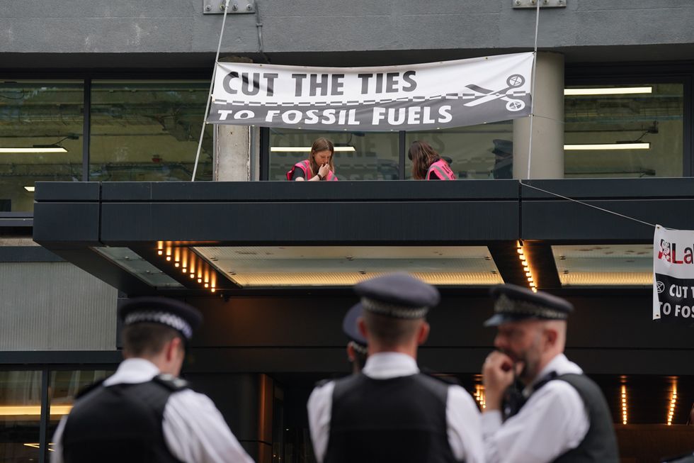 \u200bTwo protesters climbed onto the roof of the building to set off the canisters