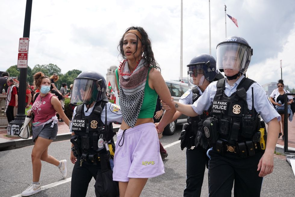 \u200bUS Park Police officers escort away a handcuffed demonstrator at a pro-Palestinian protest