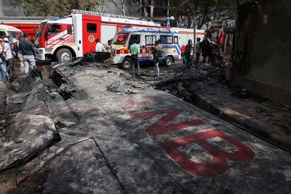 \u200bWreckage of a Boeing 787 Dreamliner lies at the site, showing part of its registration "VT-ANB",