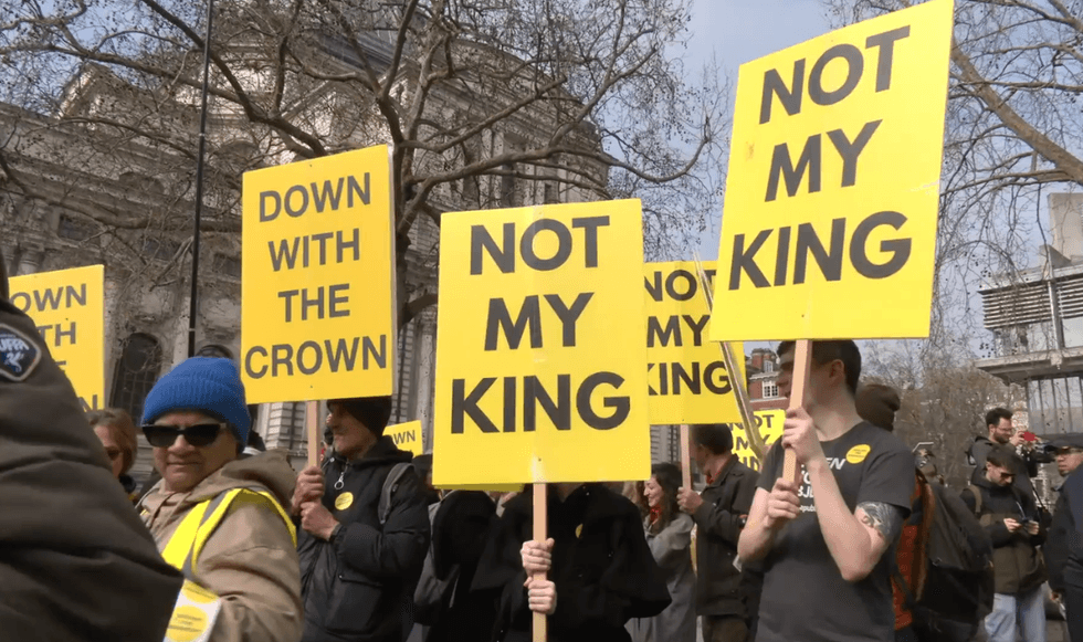 \u200bYellow placards reading 'Not My King' were visible