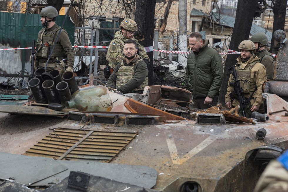 Ukraine's President Volodymyr Zelenskiy walks past destroyed Russian military vehicle as he is surrounded by Ukrainian servicemen as Russia's invasion of Ukraine continues, in Bucha, outside Kyiv, Ukraine, April 4, 2022. REUTERS/Marko Djurica